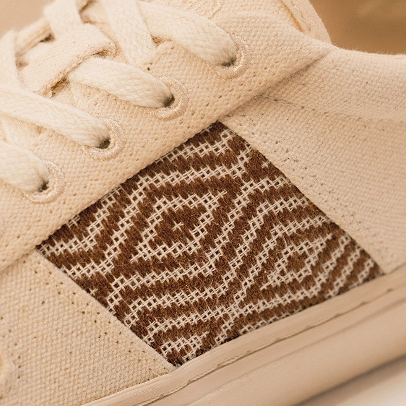 Nahaufnahme des braunen Ethno-Musters auf dem hochwertigen Canvas-Material der Sneaker.
Traditionelles vietnamesisches Handwerk trifft modernes Schuhdesign.
