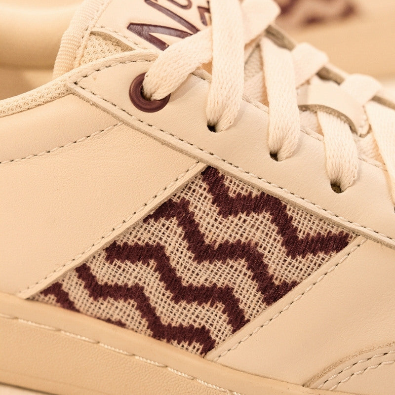 Fair produzierte Leder-Sneaker mit handgewebtem bordeauxfarbenem Detail – perfekte Kombination aus Komfort und Design.